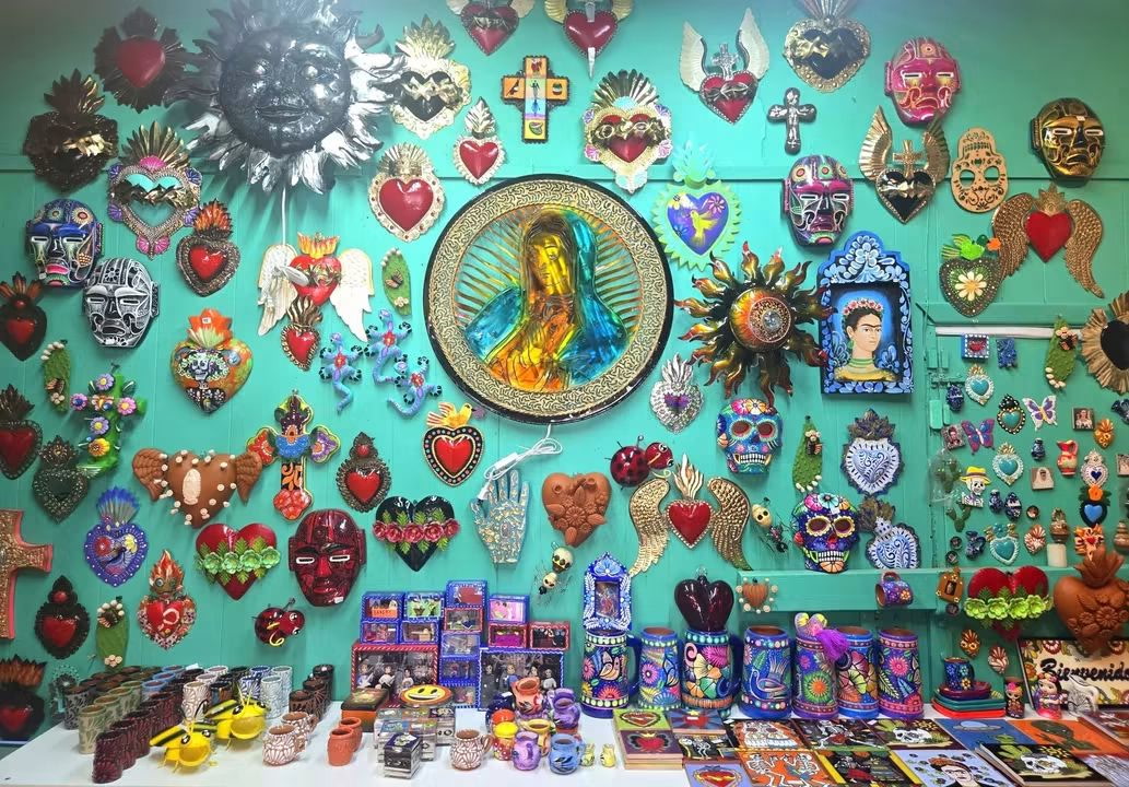 Wall of Mexican folk art hearts, milagros and framed icons